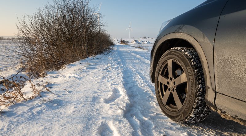 Auto v zasneženej krajina na zimných pneumatikách.