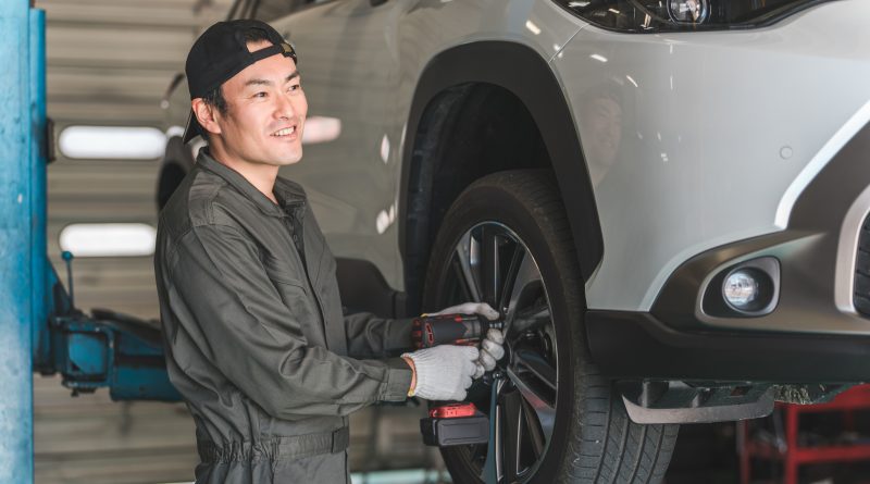 Automechanik opravujúci koleso auta.