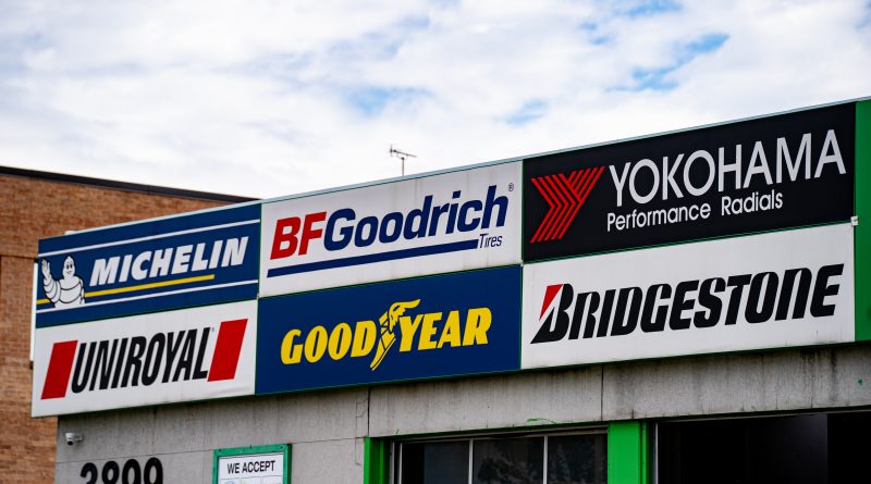 Najlepšie značky pneumatík: Ktoré ponúkajú ideálny pomer ceny a kvality? Budova s bilbordami značiek pneumatik.